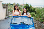 Friends posing in car sunroof, Florence, Toscana, Italy