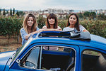Friends posing beside car in countryside, Florence, Toscana, Italy