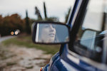 Mirror image of woman driving car