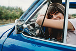 Woman leaning against steering wheel