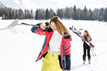 Two teenage girl skiers walking in snow covered landscape,  Tyrol, Styria, Austria