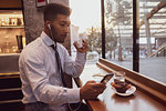 Businessman using smartphone at tea time in cafe