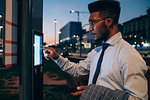 Businessman using digital information system at bus stop, Milano, Lombardia, Italy