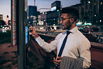 Businessman using digital information system at bus stop, Milano, Lombardia, Italy