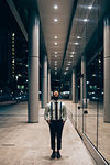 Businessman walking past mirrored wall of office building, Milano, Lombardia, Italy