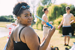 Young woman blowing bubbles in park