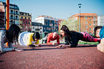 Calisthenics class in park, males and females doing push ups