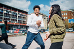 Young female and male adult friends having fun on city basketball court