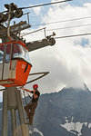 Maintenance worker climbing up cable car, Saas-Fee, Valais, Switzerland