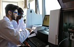 Young female and male scientists reading paperwork in laboratory