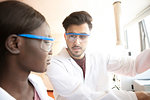 Young female and male scientists having discussion in laboratory