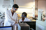 Young male and female scientists looking at results in laboratory, cropped