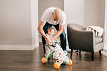 Father playing with baby daughter in living room, portrait