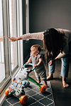 Mother with baby daughter looking out through patio door