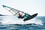 Young man windsurfing above ocean waves, Limnos, Khios, Greece