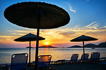 Beach umbrellas and sun loungers at sunset, Limnos, Khios, Greece