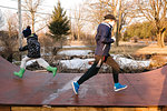 Girl and brother running in opposite directions on rural skateboard ramp