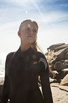 Young female surfer looking sideways on beach, Cape Town, Western Cape, South Africa