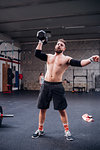 Young man lifting dumbbell in gym