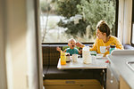 Mother feeding baby breakfast in motorhome