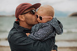 Father kissing baby on beach