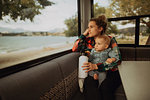 Mother and baby looking out window of motorhome, Wanaka, Taranaki, New Zealand