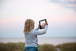 Girl taking photograph with tablet PC