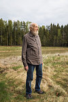 Senior man standing in rural field