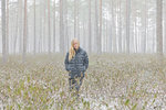 Young woman walking through a snowy forest