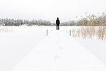 Mature woman standing next to frozen lake in Ostergotland, Sweden