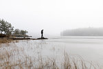 Man on rocks in frozen lake in Lotorp, Sweden