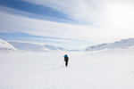 Woman skiing by mountains on Kungsleden train in Lapland, Sweden