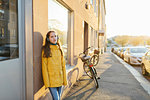 Girl wearing headphones on sidewalk