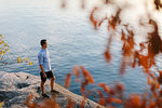 Man standing on rock by sea