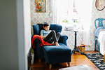 Boy wearing headphones on armchair