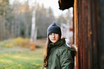 Girl wearing beanie by wooden wall