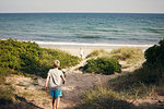 Boy and girl walking to beach