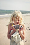 Girl carrying rock on beach