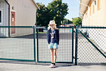 Girl wearing hat by gate