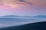 Silhouettes of hills at sunset in Scousburgh, Scotland