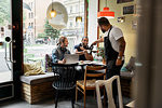 Barista serving young men in cafe