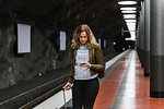 Young woman with suitcase at subway station