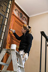 Painter painting door in apartment building