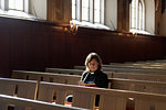 Priest reading bible on church pew