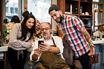 Barbers looking at colleague’s smartphone