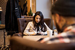 Young woman sitting at table in barbershop