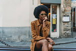 Young woman with afro hair waiting in front of shop
