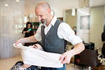 Hairdresser drying customer's face and hair with towel in barber shop