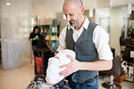 Hairdresser drying customer's face and hair with towel in barber shop