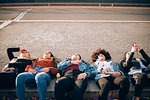 Friends lying on kerb, Milan, Italy